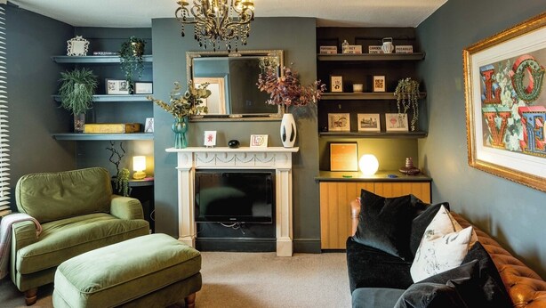 A living room with a fireplace, green sofas, a black leather couch, and a chandelier. - Historic 2BR Home - Garden, BBQ, Parking (Greater London)