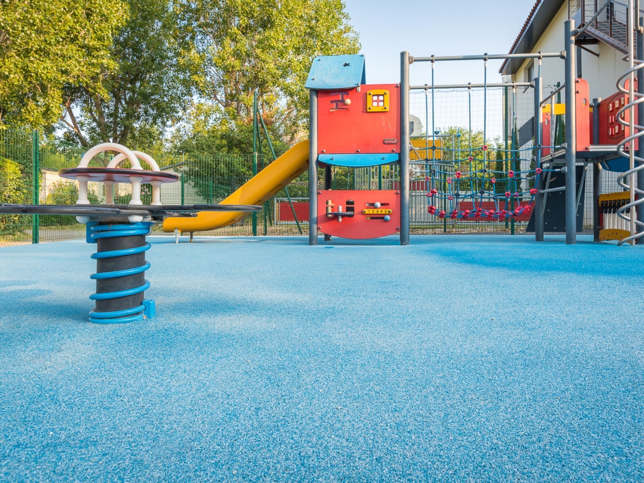 A playground with a seesaw, a slide, and climbing structures.