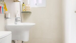 Un baño moderno con inodoro, lavamanos y ventana.