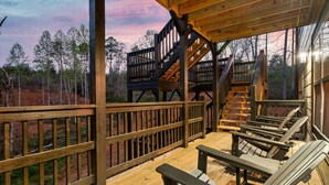Une terrasse en bois avec des sièges extérieurs et un escalier menant à une zone abritée.