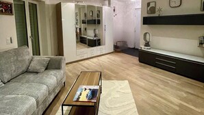 Ein modernes Wohnzimmer mit einem grauen Sofa, einem Couchtisch und Holzboden.