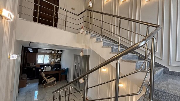 Un interior moderno con una escalera, una zona de cocina y un espacio para comer.