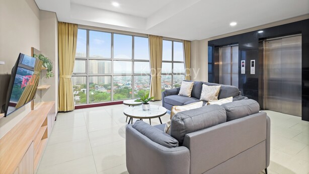 A modern living room with a sofa, a coffee table, and a TV on a wooden stand. - Suvin by Kozystay - Pondok Indah (Jakarta)