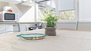Una cocina con microondas, horno y ventana con persianas.