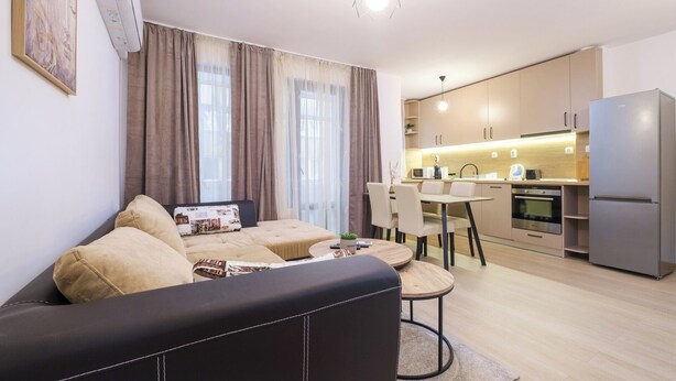 A modern apartment with a living area, dining space, kitchenette, and a large refrigerator. - Comfort 1 Bedroom App (Plovdiv)