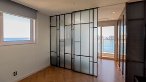 Ein modernes Interieur mit einer großen Schiebeglasdoor, die auf einen Balkon mit Blick auf die Stadt führt.
