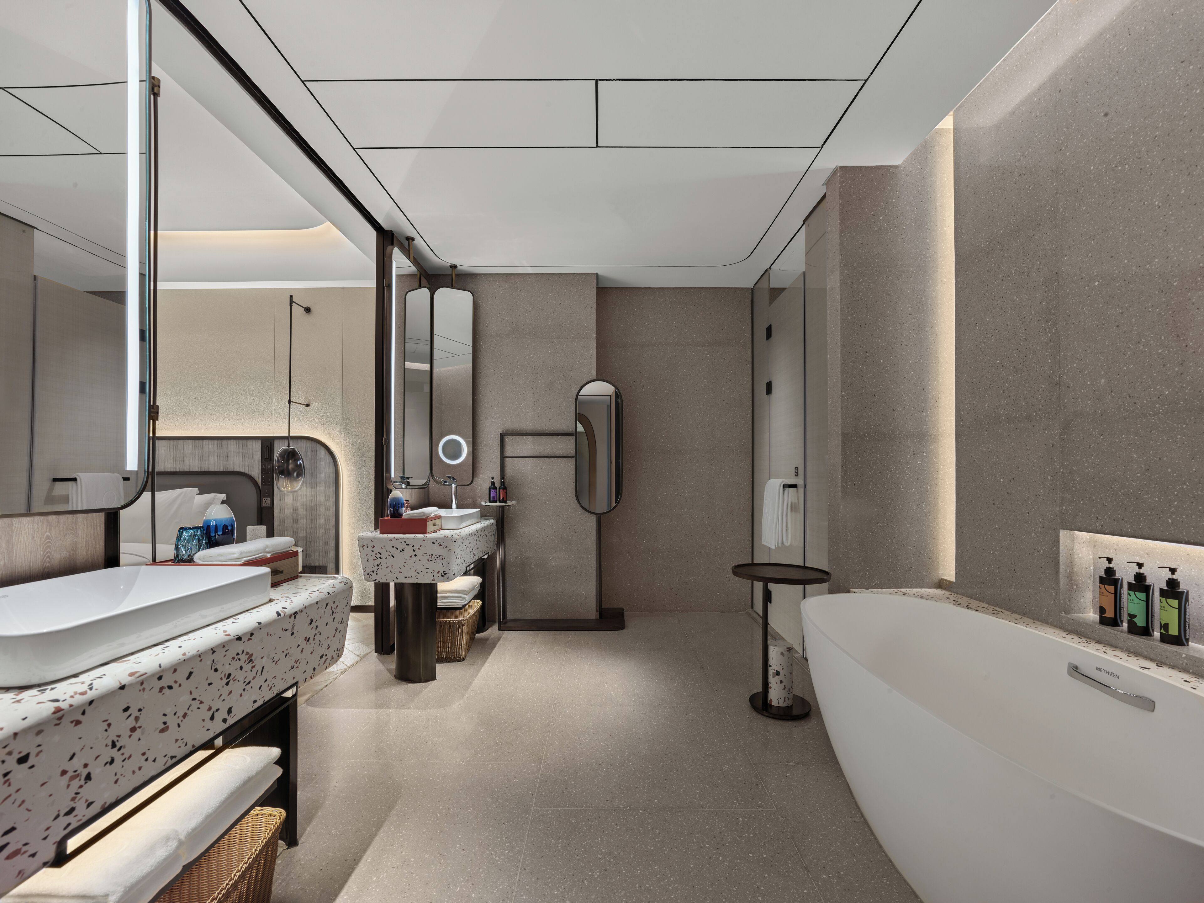 A modern bathroom with a large mirror, two sinks, a bathtub, and a towel rack.