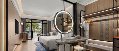 Une chambre d’hôtel moderne avec un grand lit, un miroir rond, une coiffeuse avec un lavabo et une vue sur l’extérieur.