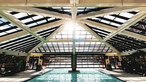 Ein Hallenbad mit hoher Decke und Dachfenstern.