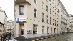 Ein Gebäude mit einem Schild für 'SCHANTL IMMOBILIENTREUHAND' im Erdgeschoss.