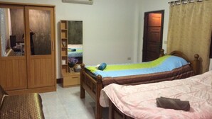 Ein Schlafzimmer mit zwei Betten, einem Kleiderschrank, einem Spiegel und einer Klimaanlage.