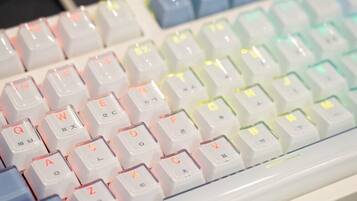 A keyboard with white keys and colorful backlighting.