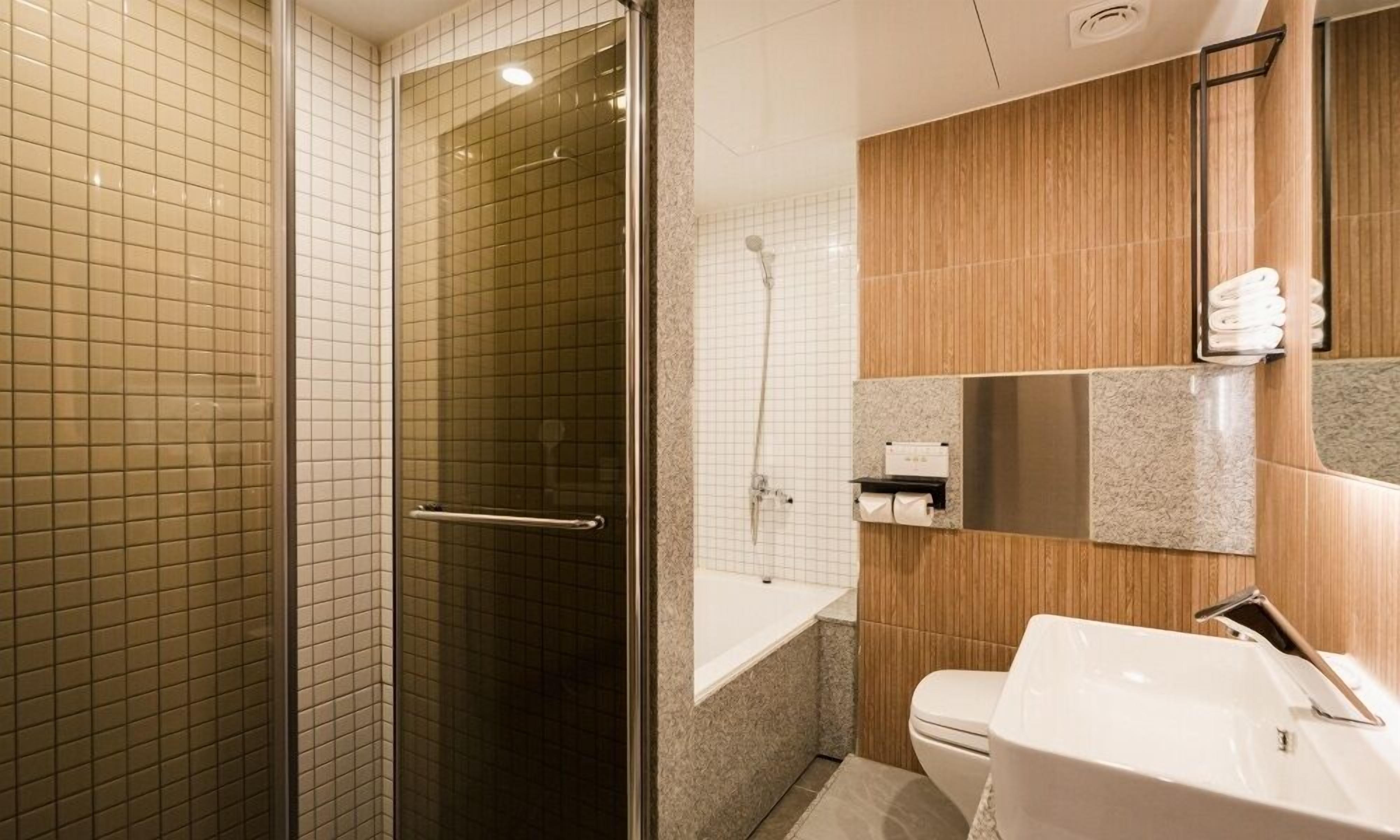 Une salle de bain moderne avec une douche à l’italienne, une baignoire et un lavabo avec un miroir.