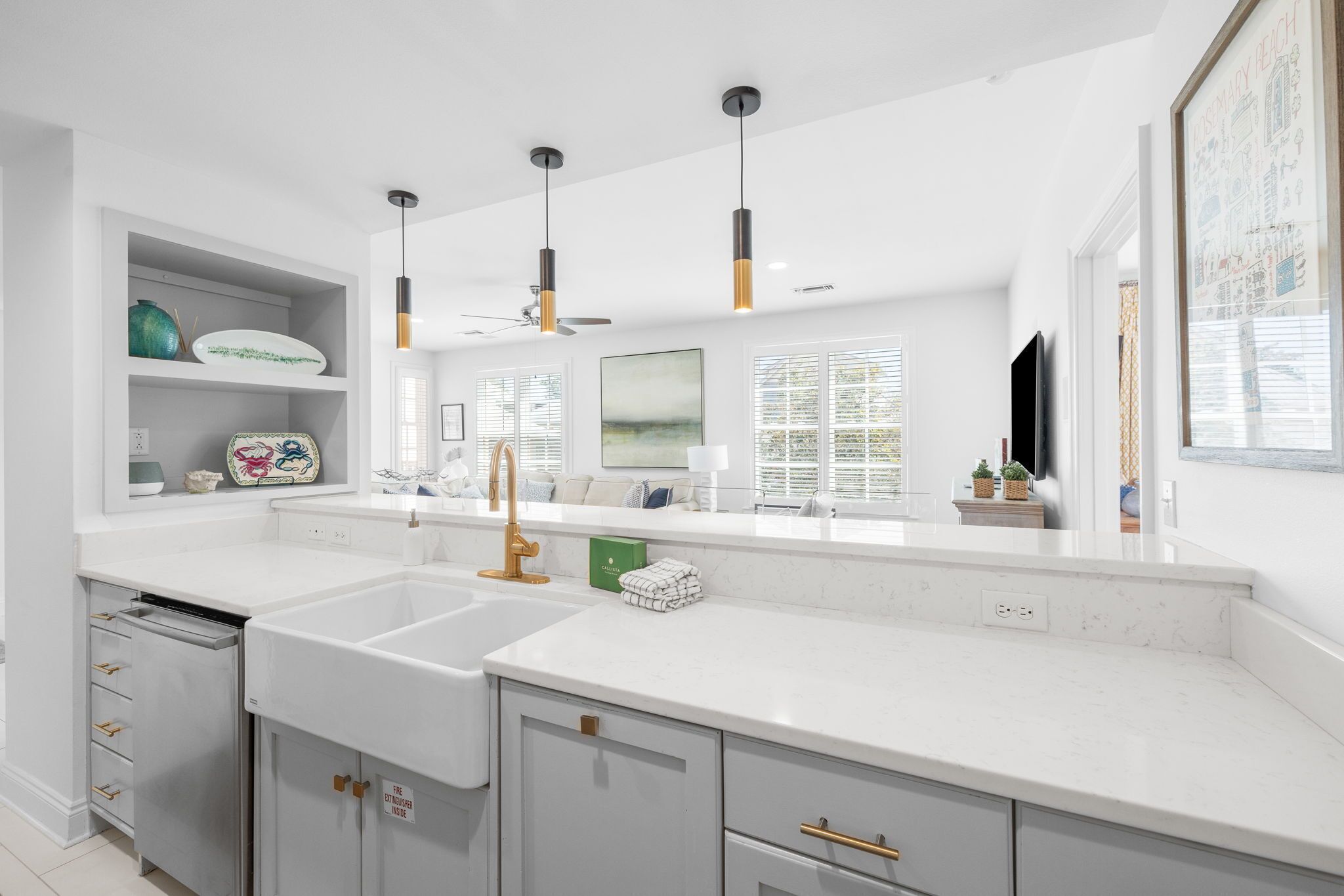 A modern kitchen with white countertops, a built-in dishwasher, and pendant lighting.