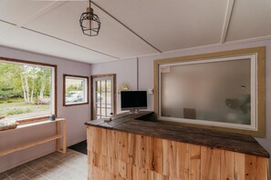 A room with a wooden desk, a computer monitor, and a large window with frosted glass. - Domaine à Ciel Ouvert (La Malbaie)