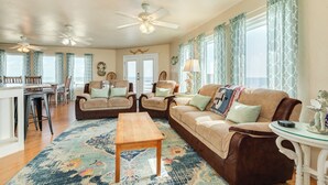 A spacious living room with a large sofa, two armchairs, a coffee table, and a dining area with a table and chairs. - Breakers Edge - Waterfront, 8 Sides of Sunshine! (Surfside Beach)