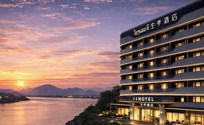 A modern hotel with multiple floors and a view of a river at sunset. - JI Hotel Vientiane Mekong Riverside (Vientiane)