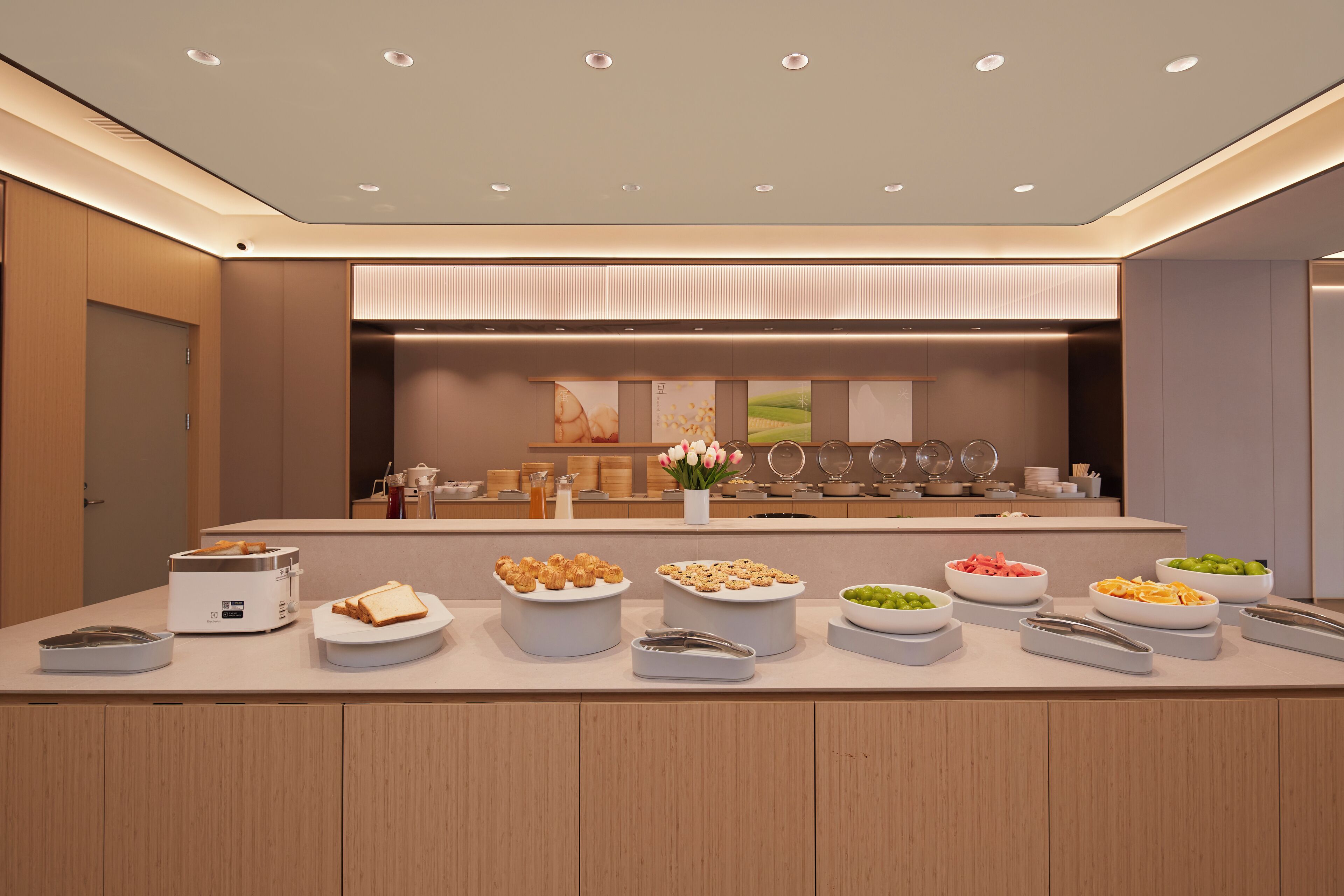 A modern buffet setup with various food items and a toaster.