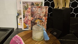 A kitchen counter with a glass jar, a book titled 'BESTOW WITHIN', and a speaker. - cheap and affordable  (Te Kōpuru)