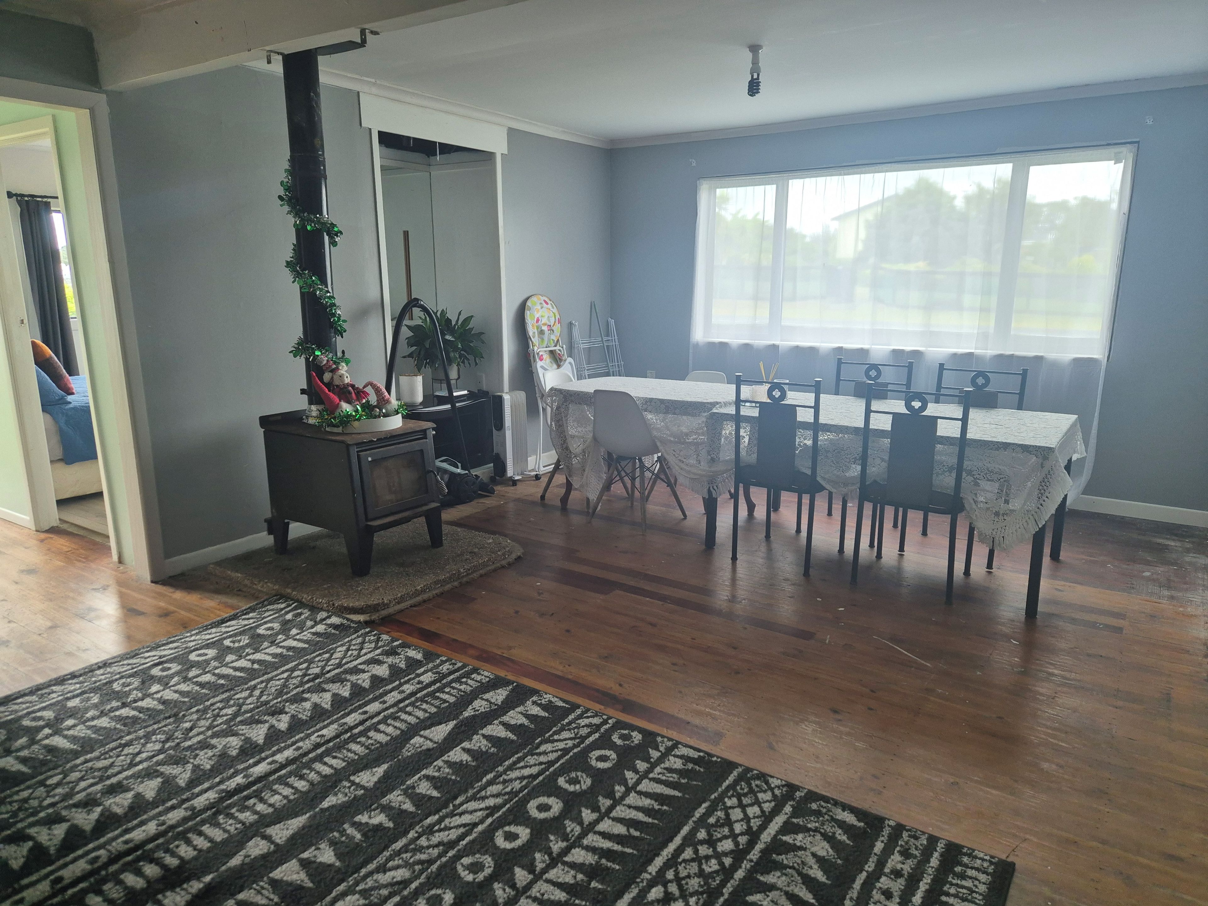A dining area with a table set for six, a fireplace, and a large window.