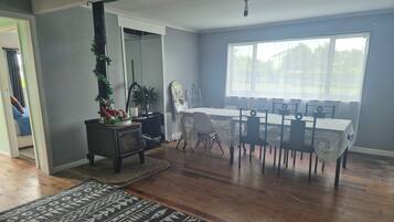 A dining area with a table set for six, a fireplace, and a large window.