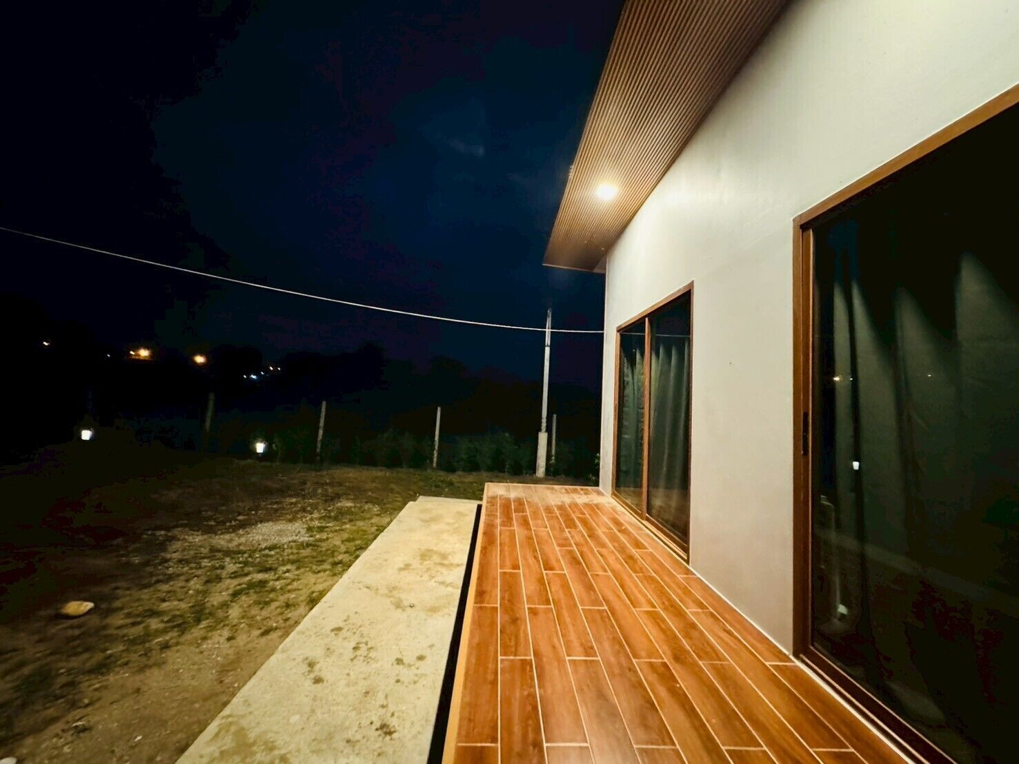 Ein modernes Gebäude mit einer Holzterrasse und großen Glasfenstern.