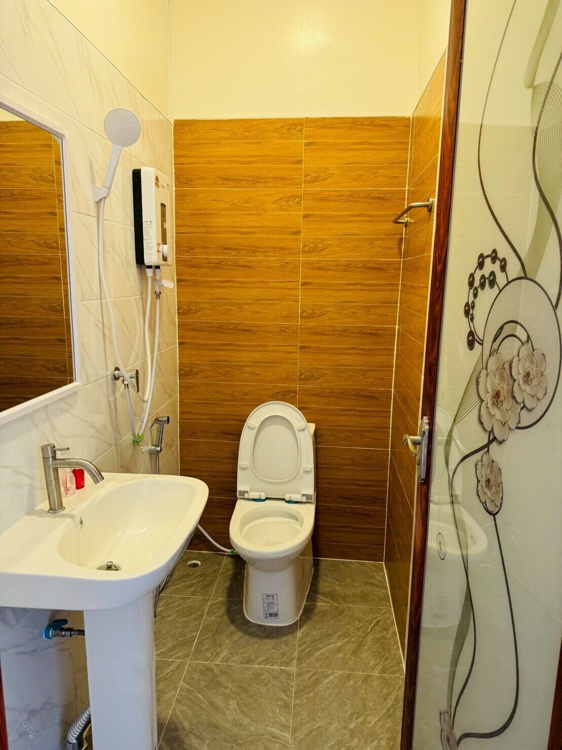 Une salle de bain avec des toilettes, un lavabo et une douche.