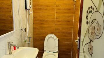 A bathroom with a toilet, sink, and shower.