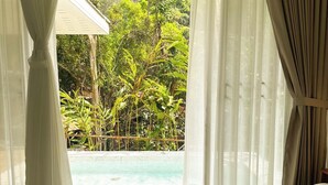 A hotel room with a bed, white curtains, and a view of a swimming pool and greenery. - Arb Pa Home And Cafe At Mae On (Mae On)