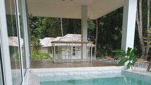 A swimming pool with clear water, surrounded by a covered area with white columns and a glass door. - Arb Pa Home And Cafe At Mae On (Mae On)