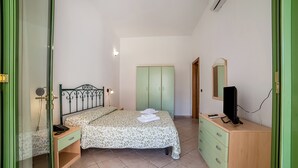 A bedroom with a bed, bedside table, wardrobe, and a TV. - Borgo Primizia B5 Pool And Sea, Otranto, Italy (Otranto)