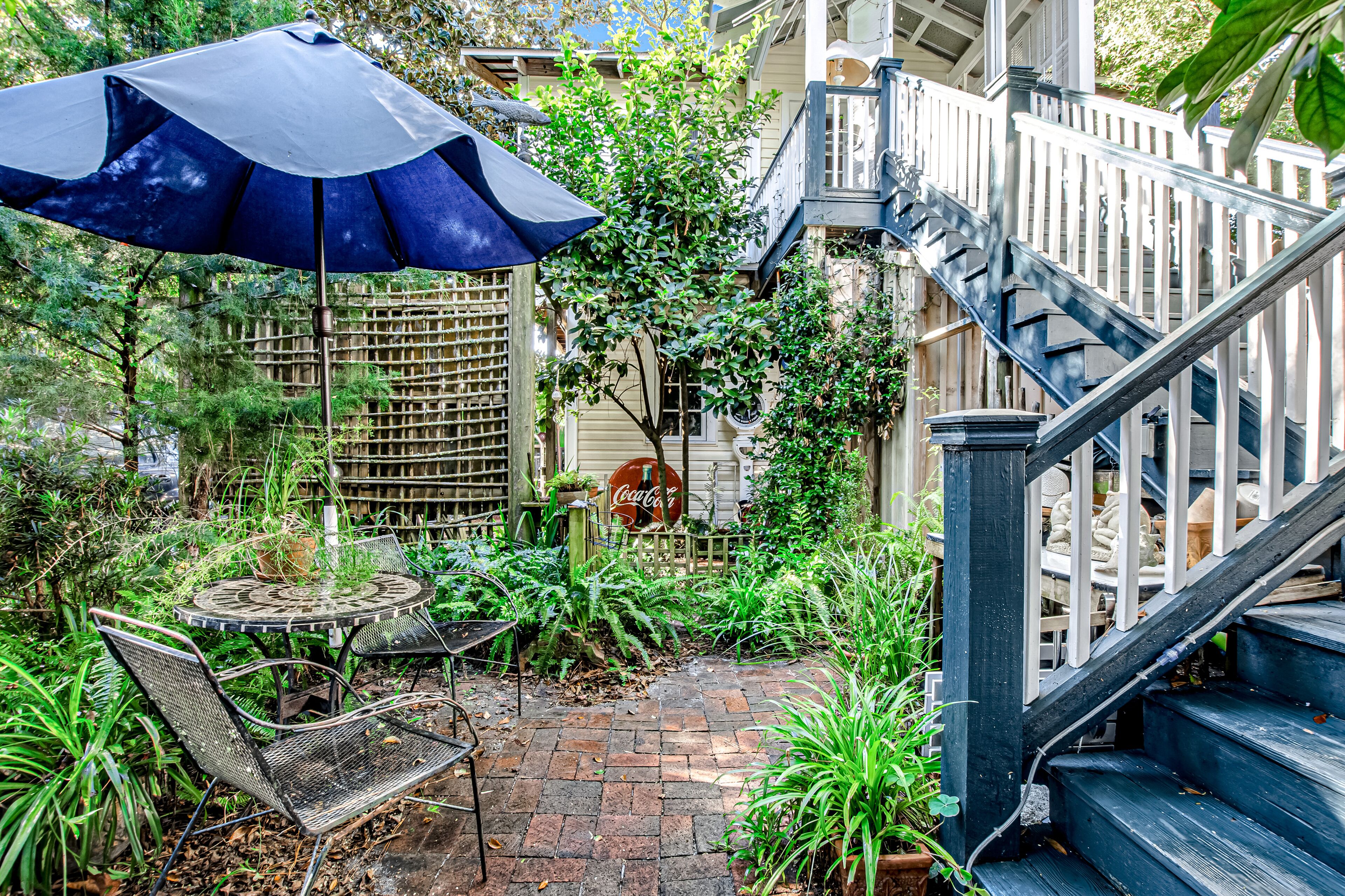 A patio with a table and chairs, a Coca-Cola sign, and a staircase.