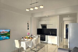 A modern kitchen with white cabinetry, a black countertop, and a stainless steel oven. - Brisa Del Mar Beachfront Apartment 115, Durres, Albania (Durres)