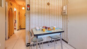 A dining area with a table set for breakfast, including plates, cups, and a fruit bowl. - Quiet apartment close to beach, Saint Mandrier, France (Saint Mandrier)