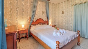 A neatly made bed with a wooden headboard, a bedside table with a lamp, and a nightstand with a lamp. - Quiet apartment close to beach, Saint Mandrier, France (Saint Mandrier)