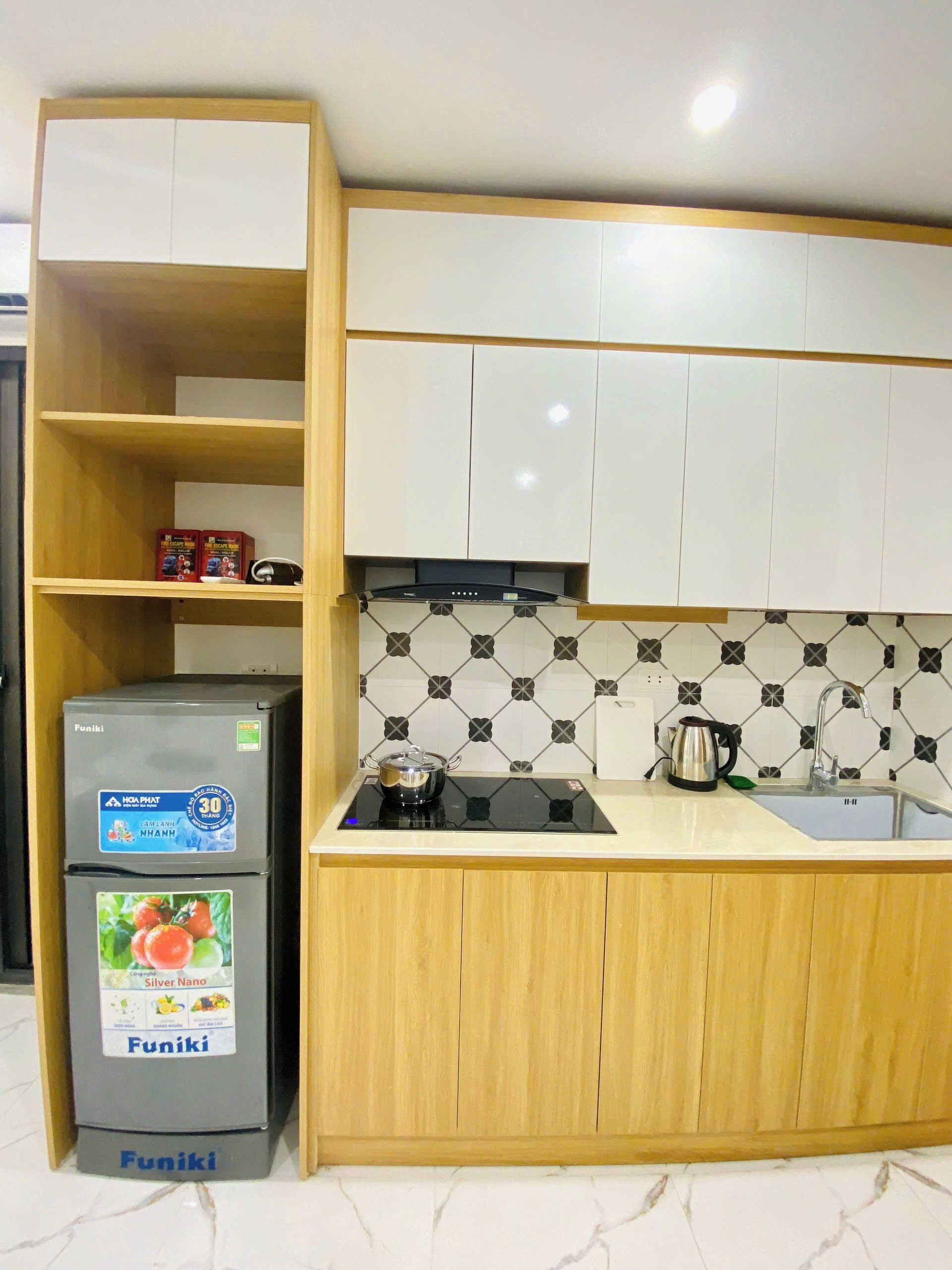 A compact kitchen with a built-in refrigerator, a stove, and a sink.