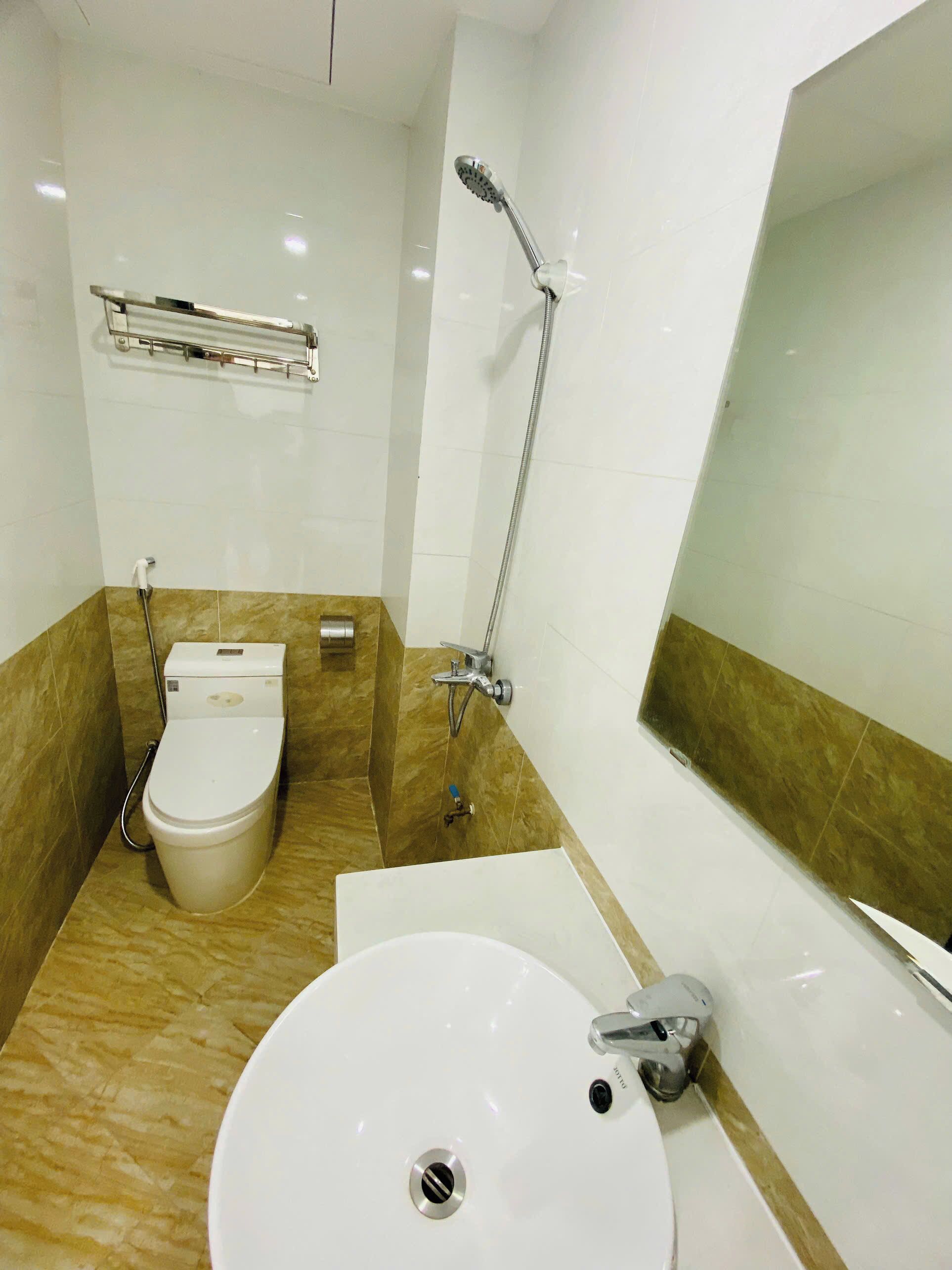 A bathroom with a toilet, bidet, sink, and shower.