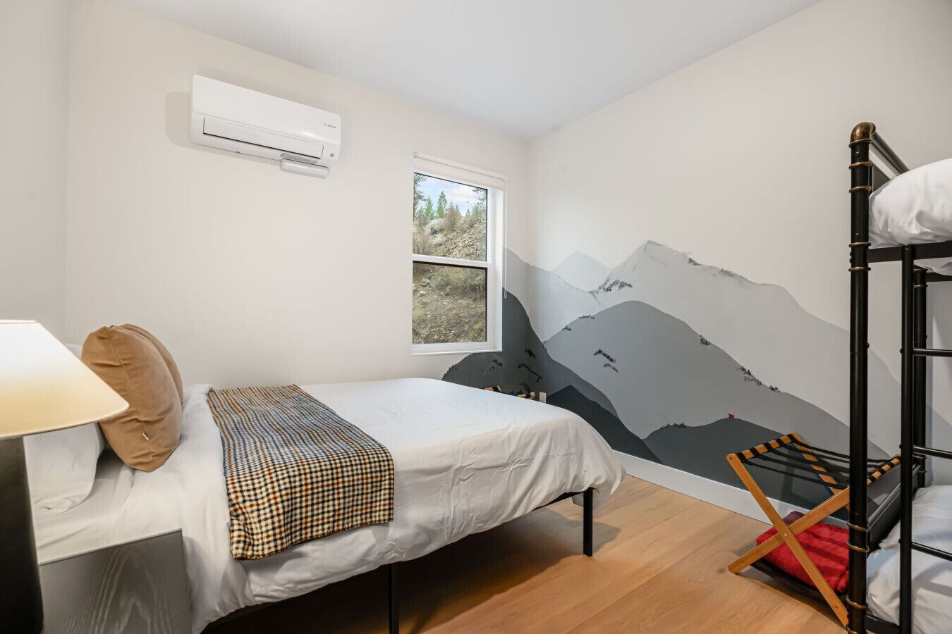 Une chambre avec un lit, une fenêtre, un climatiseur fixé au mur et un lit superposé.