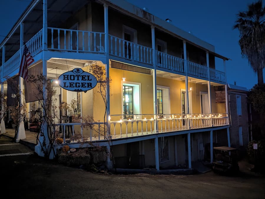 Un edificio de dos pisos con un balcón y un letrero que dice "Hotel Leeger".