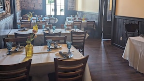Un restaurante con varias mesas, sillas y un ventilador de techo.