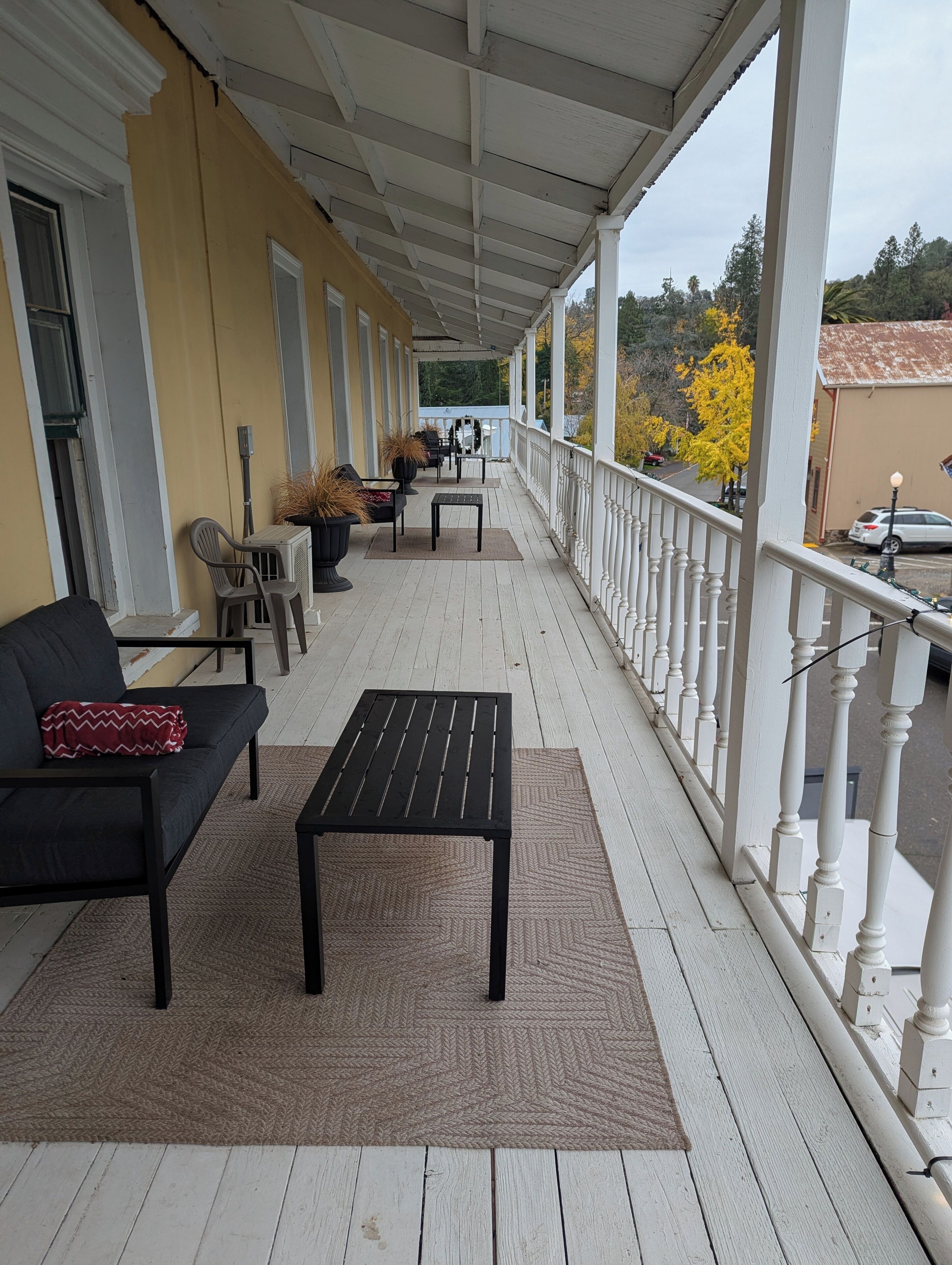 Un portico coperto con un divano, un tavolo e piante in vaso.