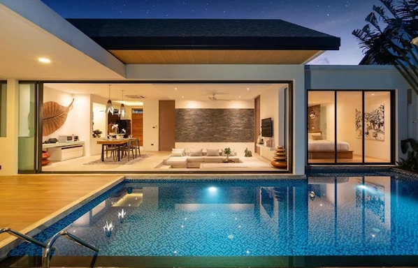 A modern house with an infinity pool, a dining area, and a living room with a large wall and a sofa. - 2BR Pool Villa Near the Sea V261 (Sa Khu)