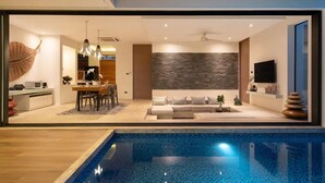 Un interior moderno con comedor, sala de estar y piscina.