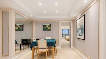 A hotel room with a dining area, a large mirror, and artwork on the walls.