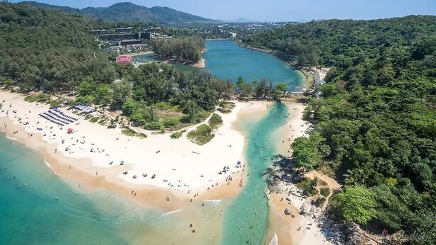 An aerial view of a beach with clear turquoise waters, a sandy shore, and dense forested hills in the background. - Stylish 3BR Pool Villa Lawan Villa (LWV1) (Chalong)
