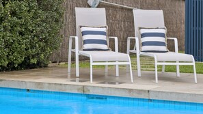 Two white lounge chairs with striped cushions by a swimming pool. - La Plage Portsea Escape with Pool (Portsea)