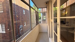 Un couloir étroit, avec de grandes fenêtres d’un côté et une porte en verre de l’autre.