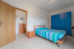 Ein Schlafzimmer mit einem Bett, einem Kleiderschrank und einem Nachttisch.