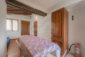 Ein Schlafzimmer mit einem Bett, einem Holzschrank und einem Fenster.