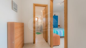 A narrow hallway leading to a bedroom with a bed and a wooden wardrobe. - IL BORGHETTO - BILOCALE IL BORGHETTO (Campo nell'Elba)